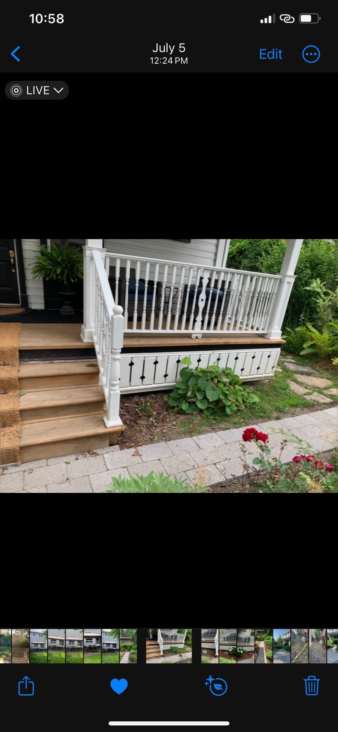 Before: garden beds beside a white-railed porch before renewal.